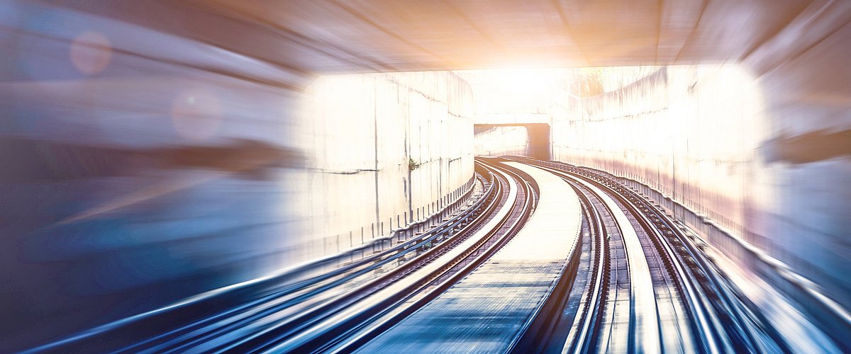 Bahnstrecke mit Schienen in einem Tunnel, der das Gefühl von Speed und Geschwindigkeit verleiht