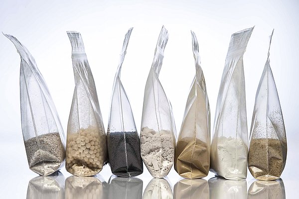 Materiabeispiele IBU-tec in Tüten: Quarz, Aktivkohle und andere