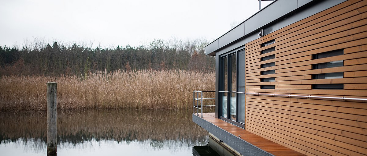 Modernes Hausboot bei Bitterfeld-Wolfen auf einem schönen See mit Schilf